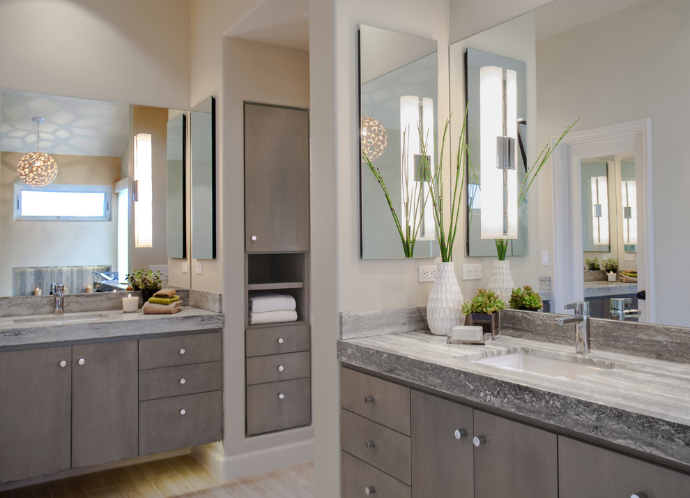 Inspiration for a large transitional master bathroom in Orange County with a freestanding tub, flat-panel cabinets, medium wood cabinets, a one-piece toilet, beige tile, pebble tile, an undermount sink, grey walls, porcelain floors, soapstone benchtops and an open shower.