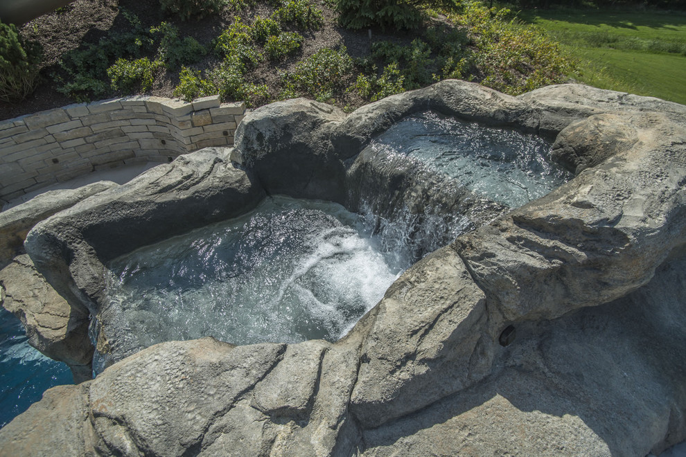 Example of a large backyard stone and custom-shaped pool fountain design in Chicago