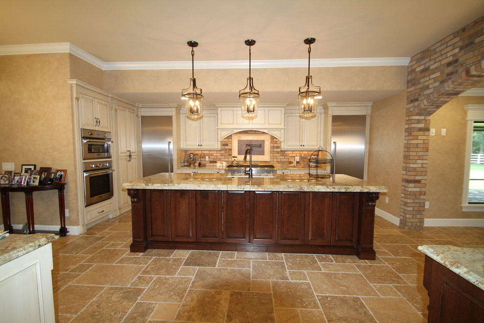 This is an example of a mid-sized transitional l-shaped eat-in kitchen in Orlando with an undermount sink, raised-panel cabinets, white cabinets, granite benchtops, beige splashback, brick splashback, stainless steel appliances and with island.