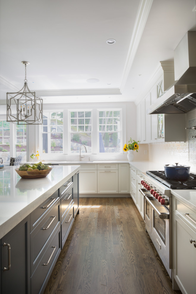 Open concept kitchen - large transitional u-shaped dark wood floor and brown floor open concept kitchen idea in Boston with an undermount sink, shaker cabinets, white cabinets, quartzite countertops, white backsplash, ceramic backsplash, stainless steel appliances, an island and white countertops