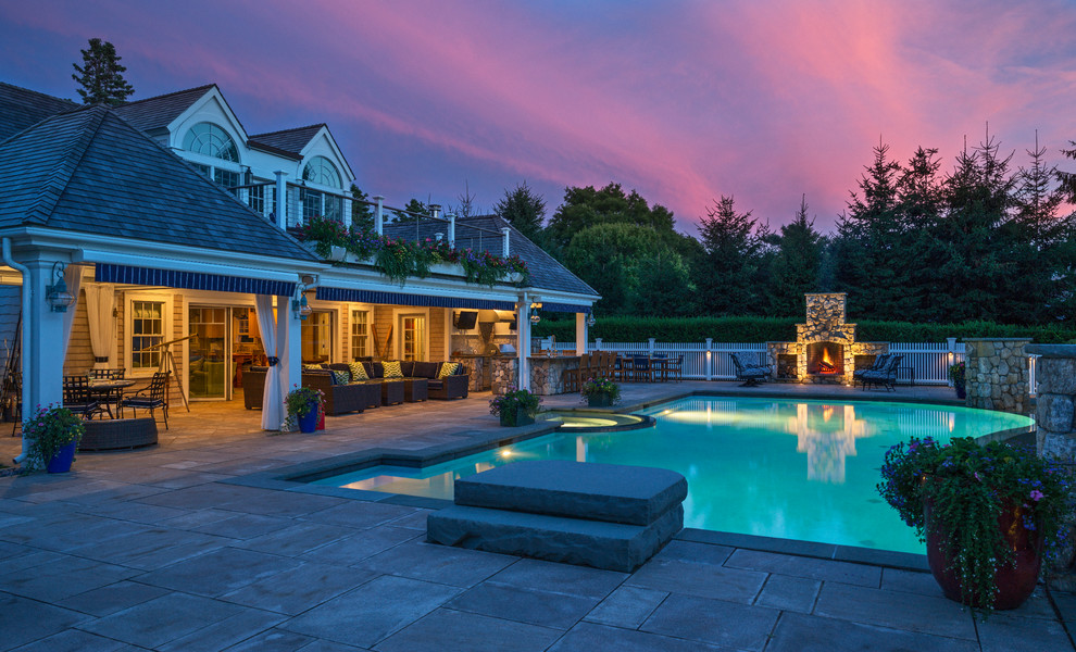 Photo of a large beach style backyard custom-shaped infinity pool in Boston with a hot tub and natural stone pavers.