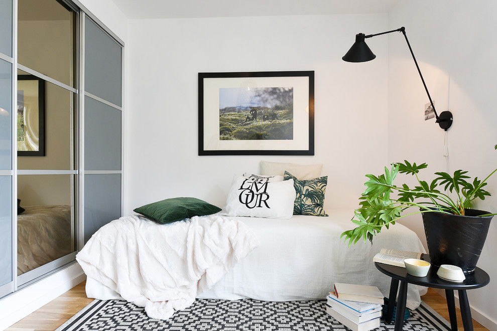 This is an example of a small scandinavian guest bedroom in Stockholm with white walls.