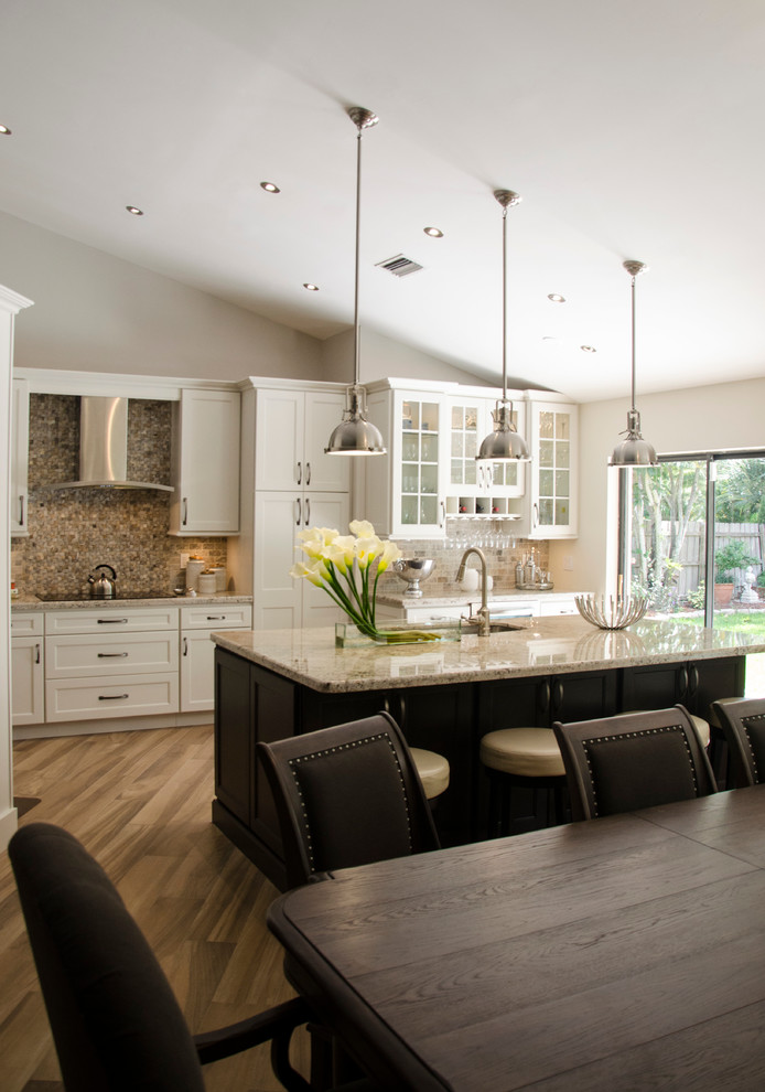 Inspiration for a large transitional porcelain tile open concept kitchen remodel in Miami with an undermount sink, shaker cabinets, white cabinets, granite countertops, multicolored backsplash, stone tile backsplash, stainless steel appliances and an island