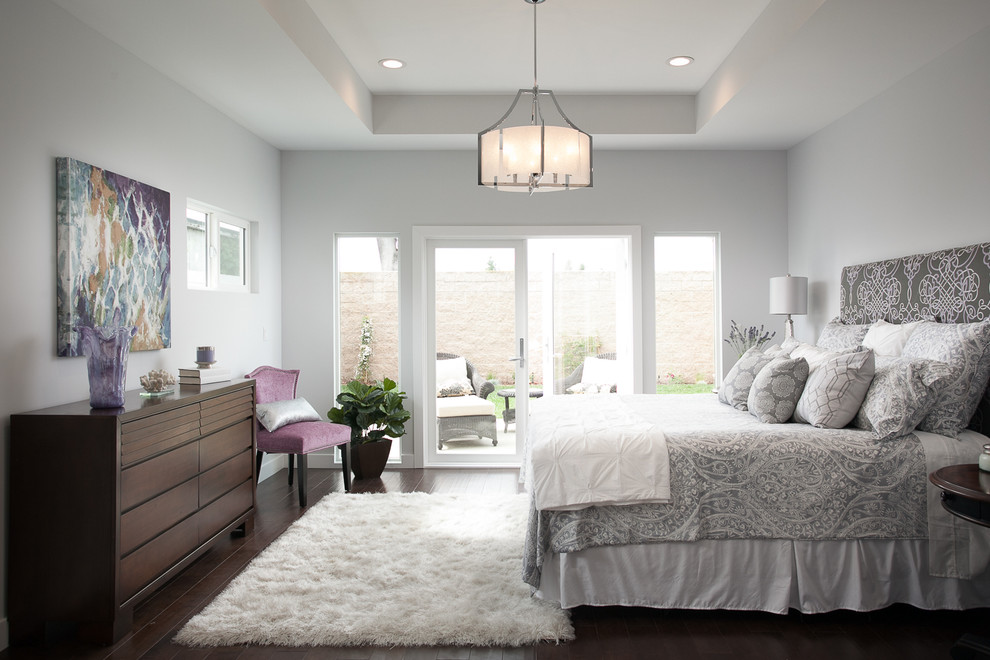 Photo of a transitional bedroom in Orange County with grey walls and dark hardwood floors.