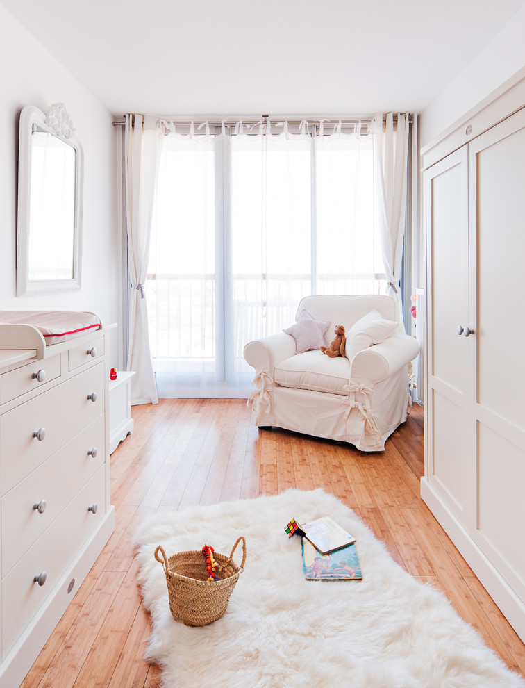 Inspiration for a large cottage gender-neutral light wood floor nursery remodel in Paris with white walls