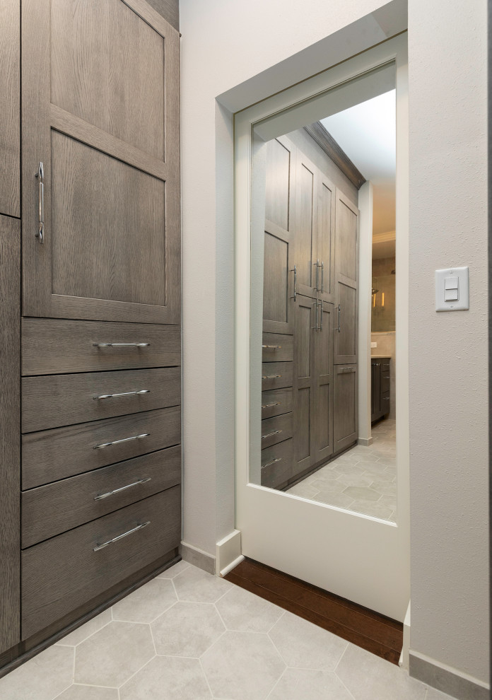 Mid-sized transitional walk-in wardrobe in Other with flat-panel cabinets, grey cabinets, porcelain floors and grey floor.
