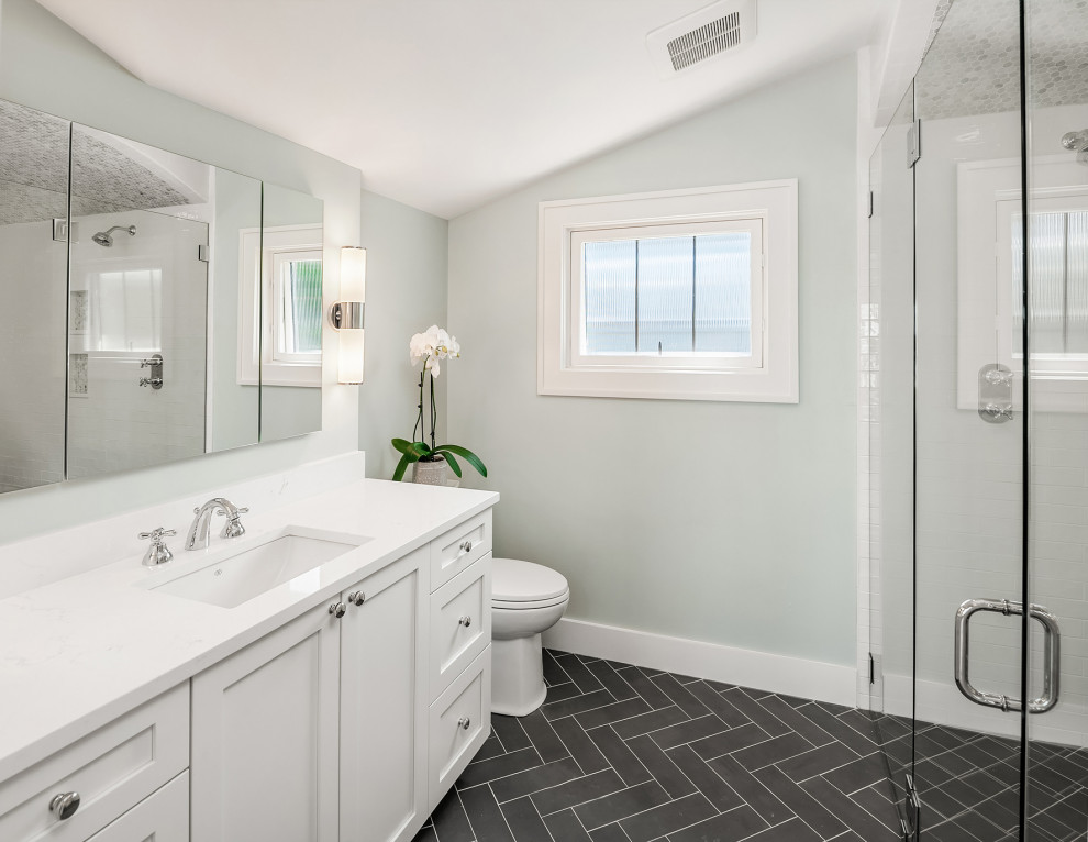 Photo of a small transitional master bathroom in Seattle with shaker cabinets, white cabinets, a freestanding tub, a curbless shower, porcelain floors, an undermount sink, engineered quartz benchtops, grey floor, a hinged shower door, white benchtops, a single vanity, a built-in vanity, vaulted, a two-piece toilet and blue walls.