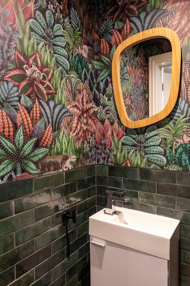 Small midcentury powder room in London with green tile and subway tile.