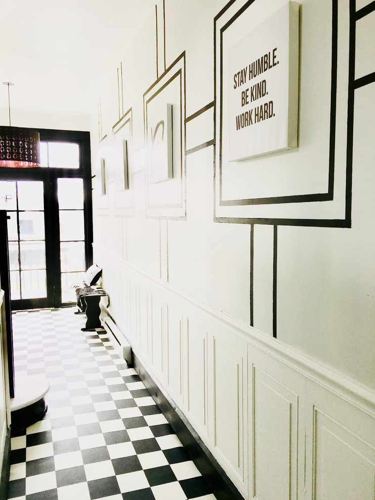 Inspiration for a mid-sized transitional vinyl floor and black floor entry hall remodel with white walls and a black front door