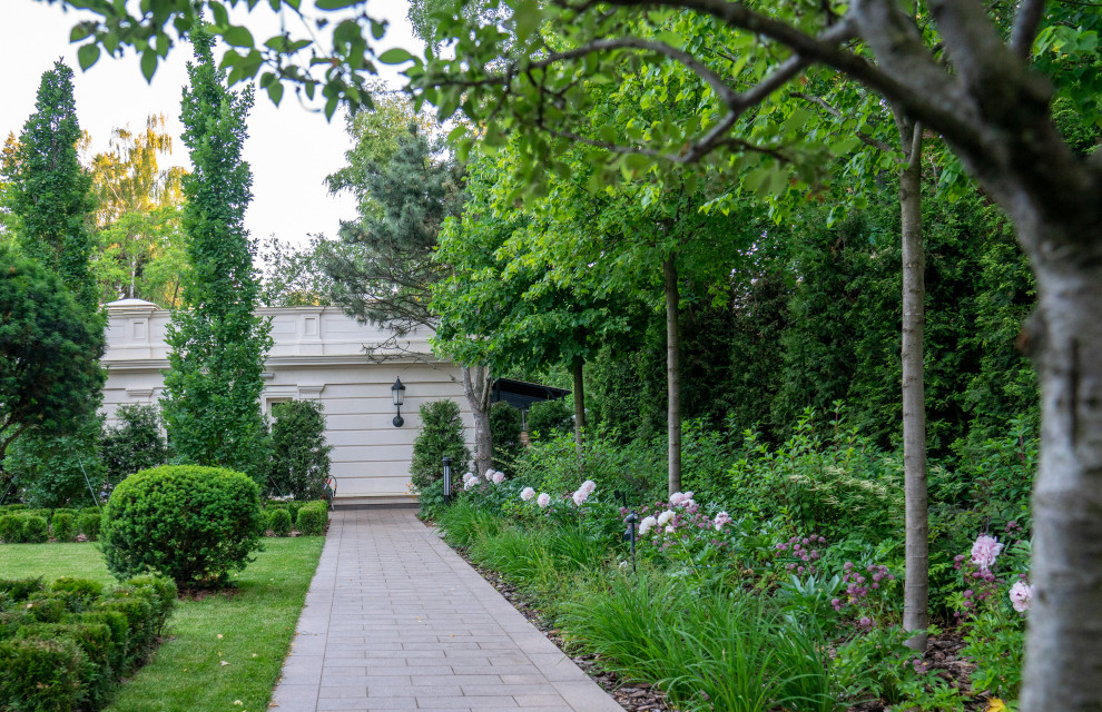 Esempio di un giardino tradizionale esposto a mezz'ombra di medie dimensioni e dietro casa in estate con pavimentazioni in pietra naturale e recinzione in legno
