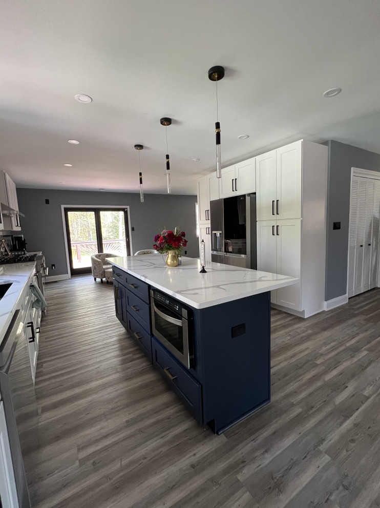Idéer för att renovera ett stort funkis grå grått kök, med en dubbel diskho, skåp i shakerstil, blå skåp, bänkskiva i kvarts, vitt stänkskydd, stänkskydd i porslinskakel, rostfria vitvaror, vinylgolv, en köksö och grått golv