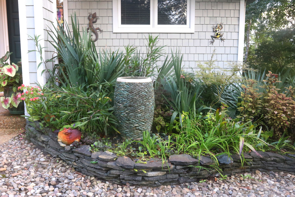 This is an example of a front yard garden in Other with with raised garden bed and river rock.