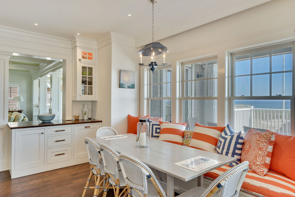 Expansive beach style u-shaped kitchen in New York with white cabinets, granite benchtops, stainless steel appliances, dark hardwood floors, with island, brown floor and white benchtop.