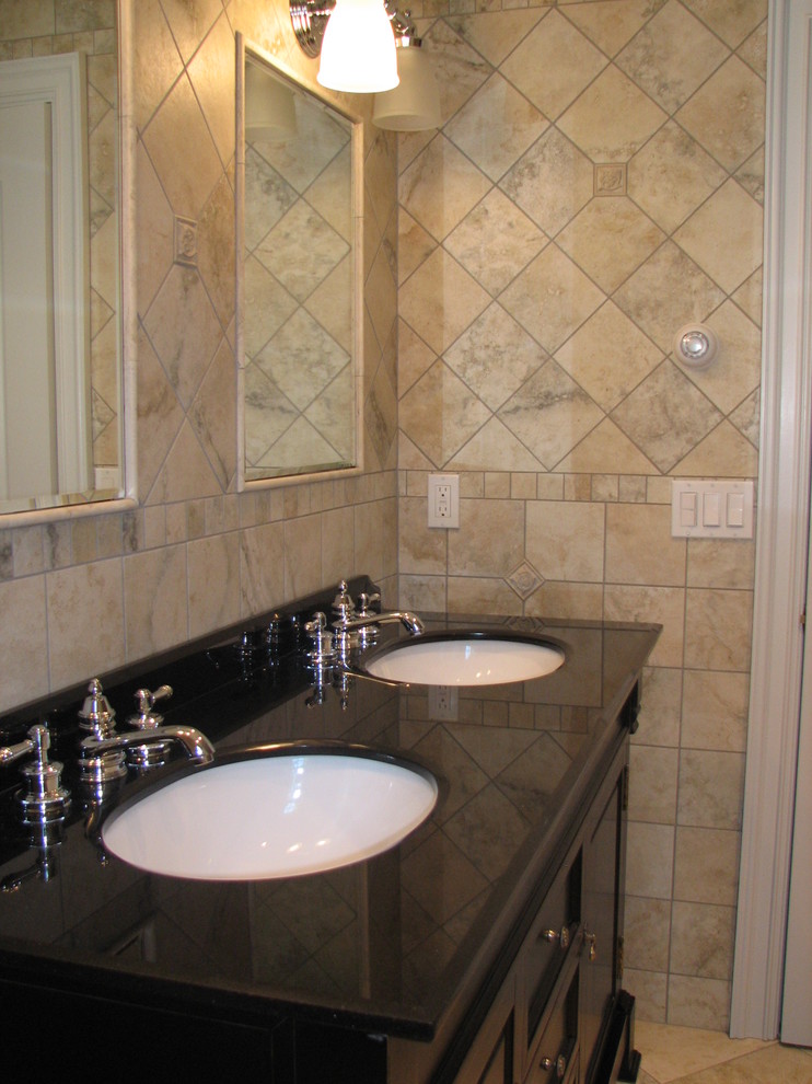Photo of a mid-sized traditional kids bathroom in New York with an undermount sink, raised-panel cabinets, black cabinets, marble benchtops, an alcove tub, a two-piece toilet, multi-coloured tile, ceramic tile, multi-coloured walls and ceramic floors.