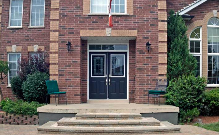 Large brick floor double front door photo in Toronto with red walls and a black front door