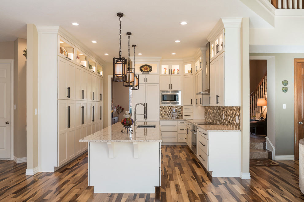 Mid-sized transitional galley light wood floor kitchen pantry photo in Dallas with an undermount sink, shaker cabinets, white cabinets, granite countertops, beige backsplash, ceramic backsplash, stainless steel appliances and an island