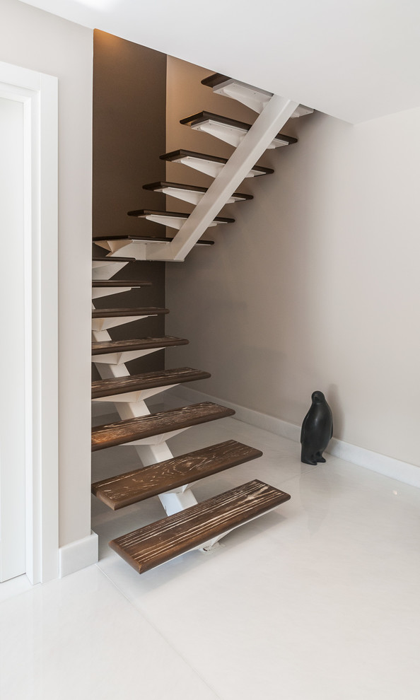This is an example of a mid-sized contemporary wood u-shaped staircase in Miami with open risers.