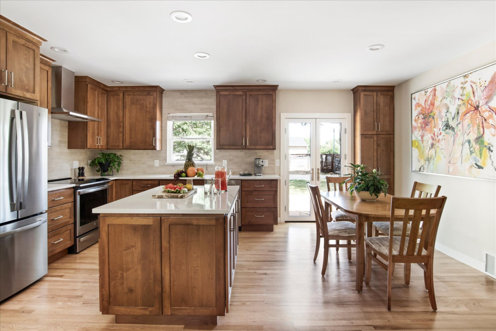 Inspiration for a small transitional l-shaped light wood floor and brown floor eat-in kitchen remodel in Denver with an undermount sink, shaker cabinets, medium tone wood cabinets, beige backsplash, stainless steel appliances, an island and white countertops