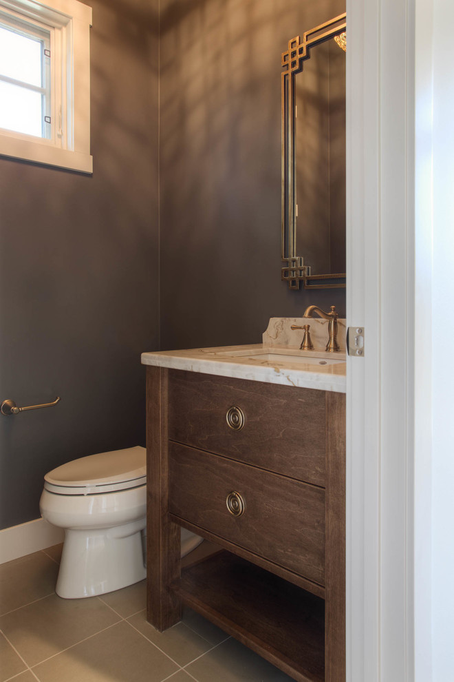 Photo of a traditional powder room in Calgary with marble benchtops and dark wood cabinets.