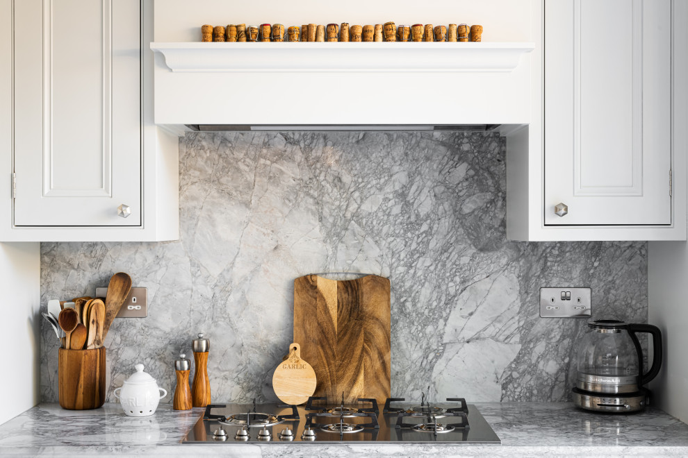 Inspiration for a mid-sized traditional single-wall eat-in kitchen in London with shaker cabinets, white cabinets, quartzite benchtops, grey splashback, granite splashback, stainless steel appliances, with island and grey benchtop.