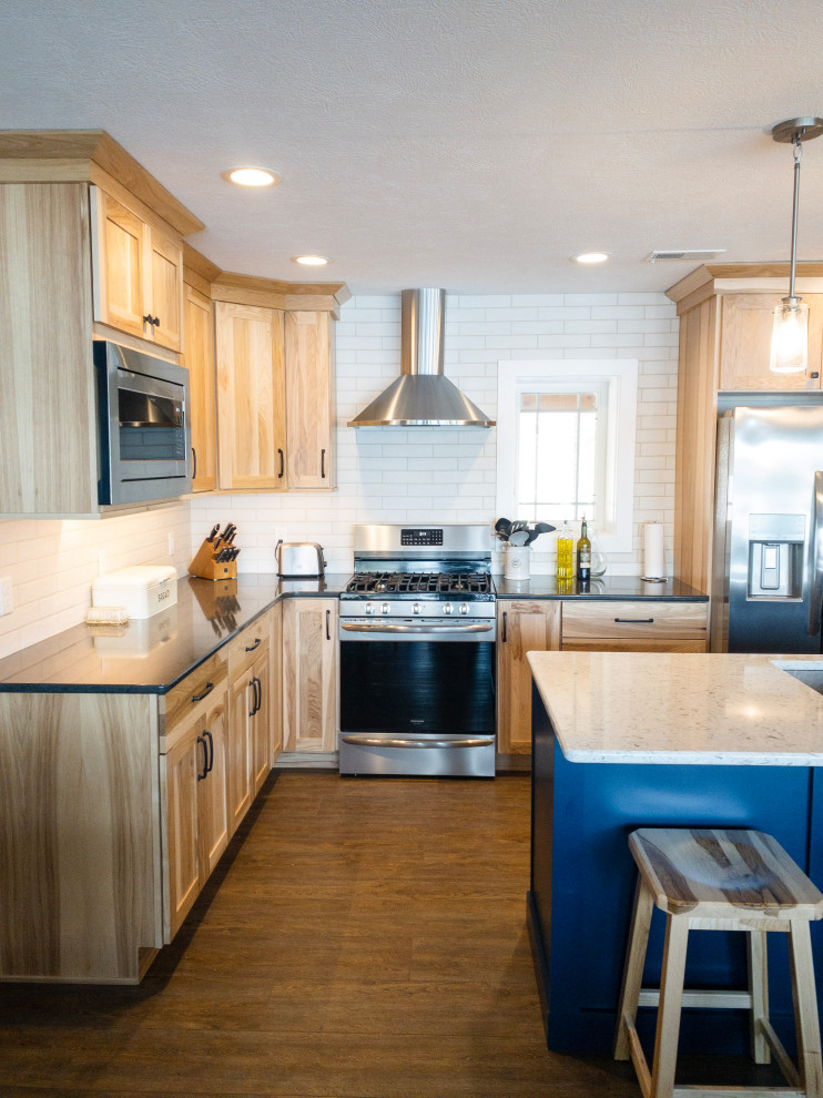 Mid-sized transitional l-shaped medium tone wood floor and brown floor eat-in kitchen photo with an undermount sink, flat-panel cabinets, light wood cabinets, quartz countertops, yellow backsplash, subway tile backsplash, stainless steel appliances, an island and white countertops