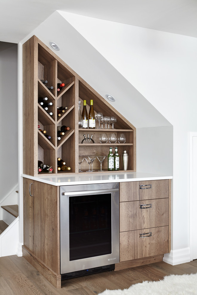 Photo of a contemporary single-wall home bar in Toronto with no sink, light wood cabinets, light hardwood floors and flat-panel cabinets.