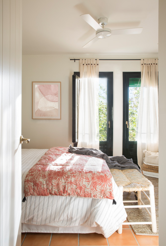 Imagen de dormitorio campestre sin chimenea con paredes blancas y suelo de baldosas de terracota