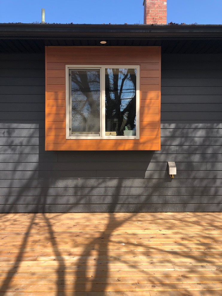 Inspiration for a small contemporary one-storey orange house exterior in Vancouver with metal siding, a hip roof and a shingle roof.