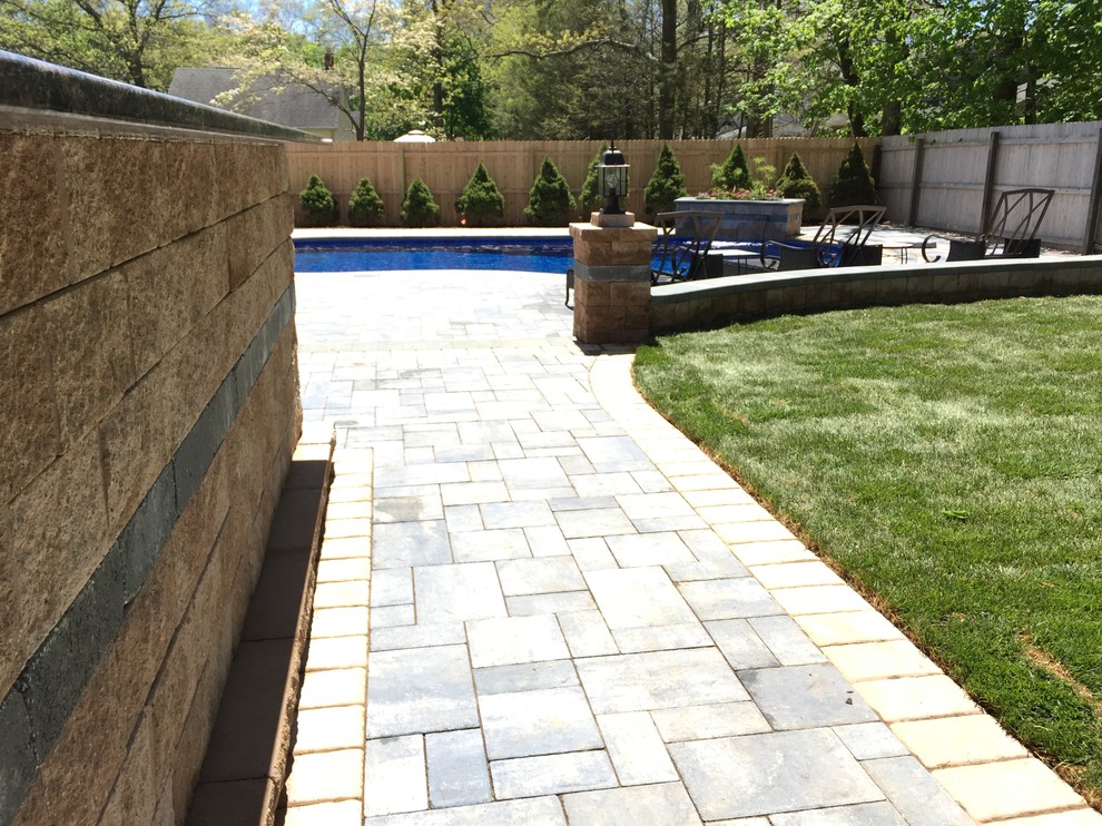 Inspiration for a large beach style backyard custom-shaped natural pool in New York with concrete pavers.