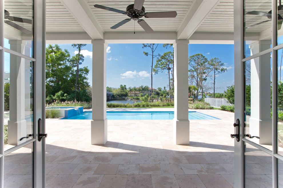 Inspiration for a large beach style backyard patio in Miami with stamped concrete and a roof extension.