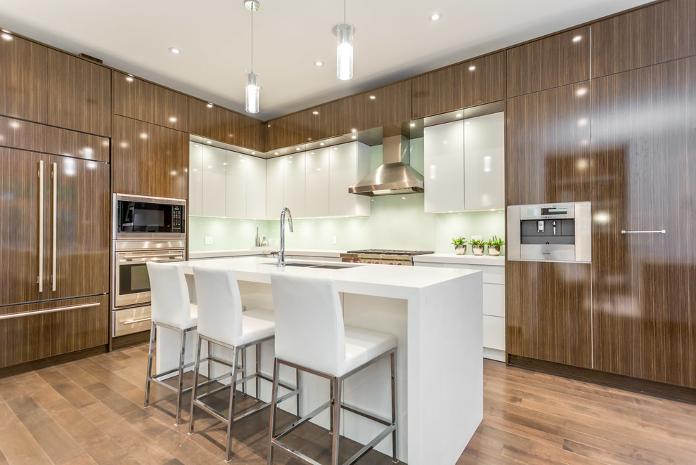 Photo of a large contemporary l-shaped separate kitchen in Toronto with a double-bowl sink, flat-panel cabinets, white splashback, glass sheet splashback, panelled appliances, light hardwood floors, with island, dark wood cabinets, quartz benchtops and brown floor.