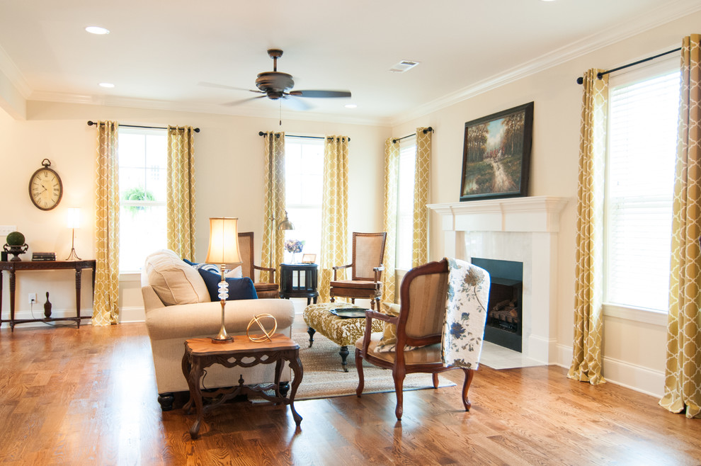 This is an example of a mid-sized country open concept living room in Birmingham with beige walls, medium hardwood floors, a standard fireplace and a stone fireplace surround.