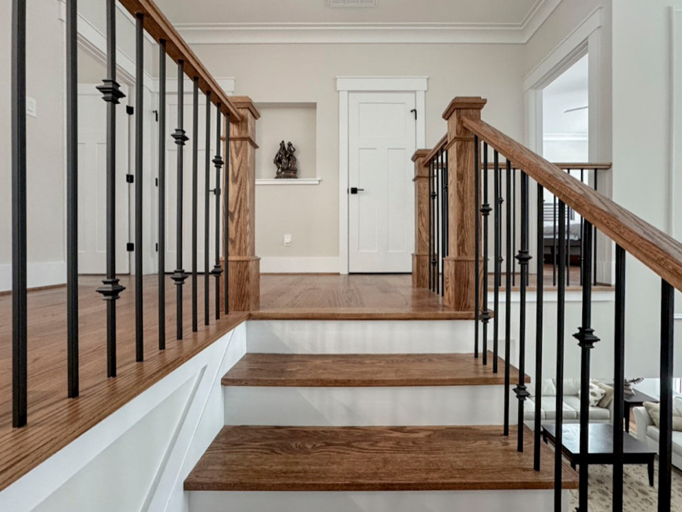 Свежая идея для дизайна: изогнутая деревянная лестница среднего размера в стиле неоклассика (современная классика) с деревянными ступенями и перилами из смешанных материалов - отличное фото интерьера