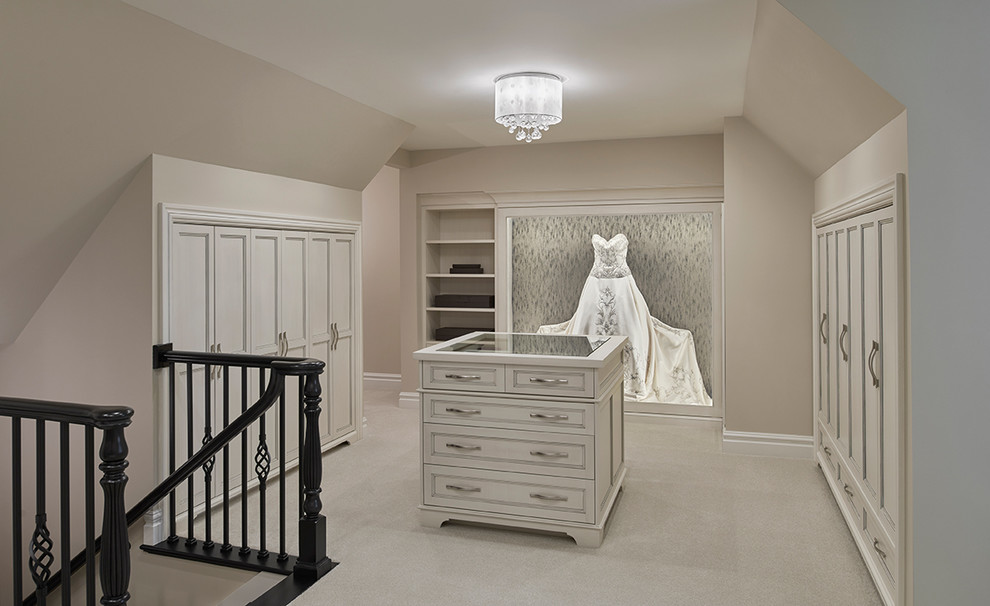 Expansive transitional women's walk-in wardrobe in Detroit with recessed-panel cabinets, white cabinets and carpet.