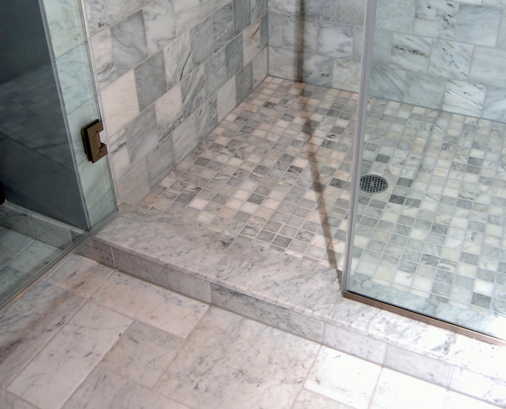 Inspiration for a large traditional master bathroom in Portland with shaker cabinets, medium wood cabinets, a drop-in tub, a corner shower, a wall-mount toilet, gray tile, stone tile, grey walls, marble floors, an undermount sink, marble benchtops, a hinged shower door and grey benchtops.