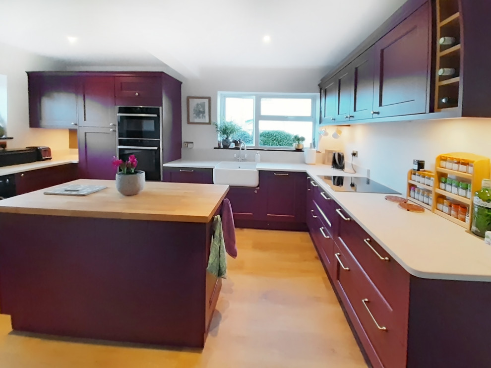 Geschlossene, Kleine Klassische Küche in U-Form mit Schrankfronten im Shaker-Stil, roten Schränken, Quarzit-Arbeitsplatte, Kücheninsel und weißer Arbeitsplatte in Cornwall