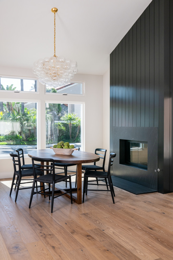 Kitchen/dining room combo - transitional light wood floor, brown floor and vaulted ceiling kitchen/dining room combo idea in Orange County with a standard fireplace and a shiplap fireplace