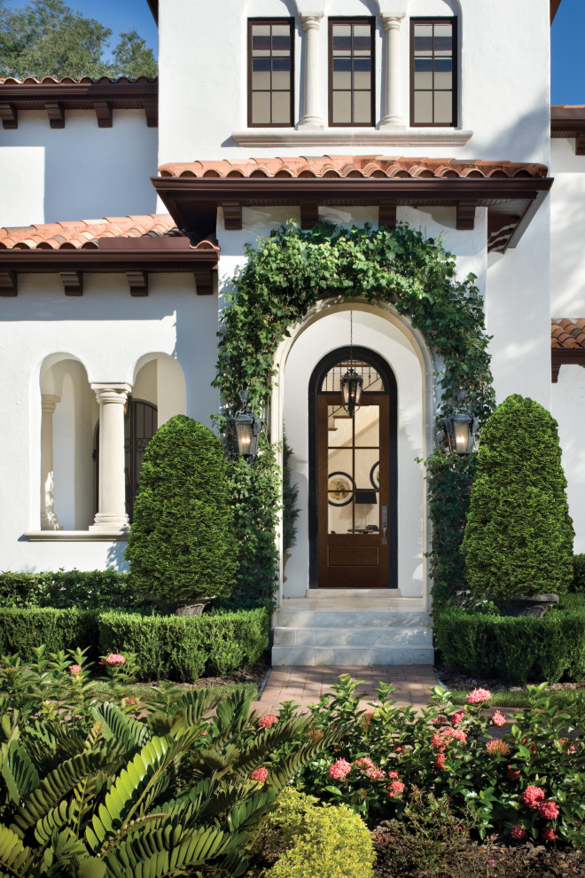 Design ideas for a large mediterranean two-storey adobe white house exterior in Los Angeles.