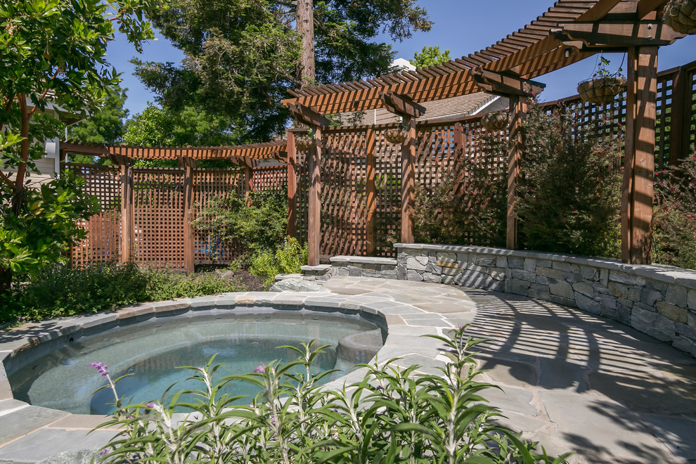 Design ideas for a small tropical backyard round natural pool in San Francisco with a water feature and natural stone pavers.