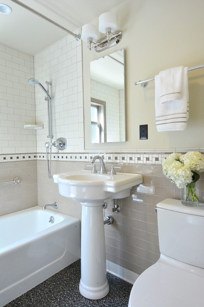 This is an example of a mid-sized transitional master bathroom in Seattle with medium wood cabinets, an alcove tub, a shower/bathtub combo, a one-piece toilet, beige tile, porcelain tile, beige walls, linoleum floors, a pedestal sink, tile benchtops, black floor and a shower curtain.