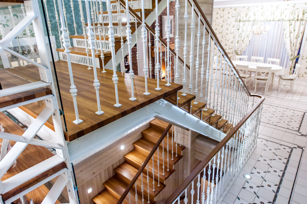 This is an example of a wood u-shaped staircase in Saint Petersburg with metal risers.