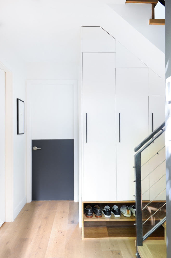 Design ideas for a contemporary mudroom in Vancouver with white walls, light hardwood floors, a single front door and a gray front door.