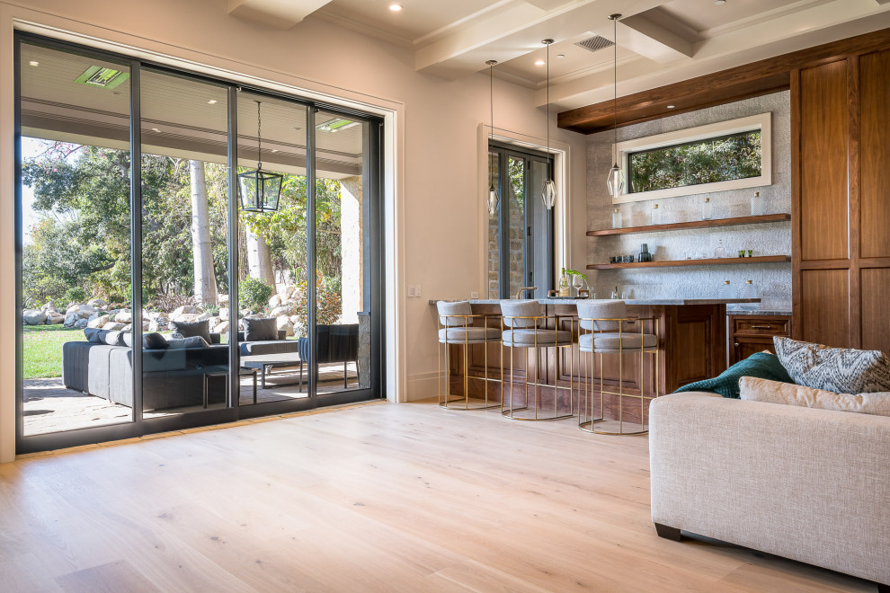 Mid-sized farmhouse u-shaped light wood floor and beige floor wet bar photo in Los Angeles with a drop-in sink, floating shelves, dark wood cabinets, marble countertops, white backsplash, stone tile backsplash and gray countertops