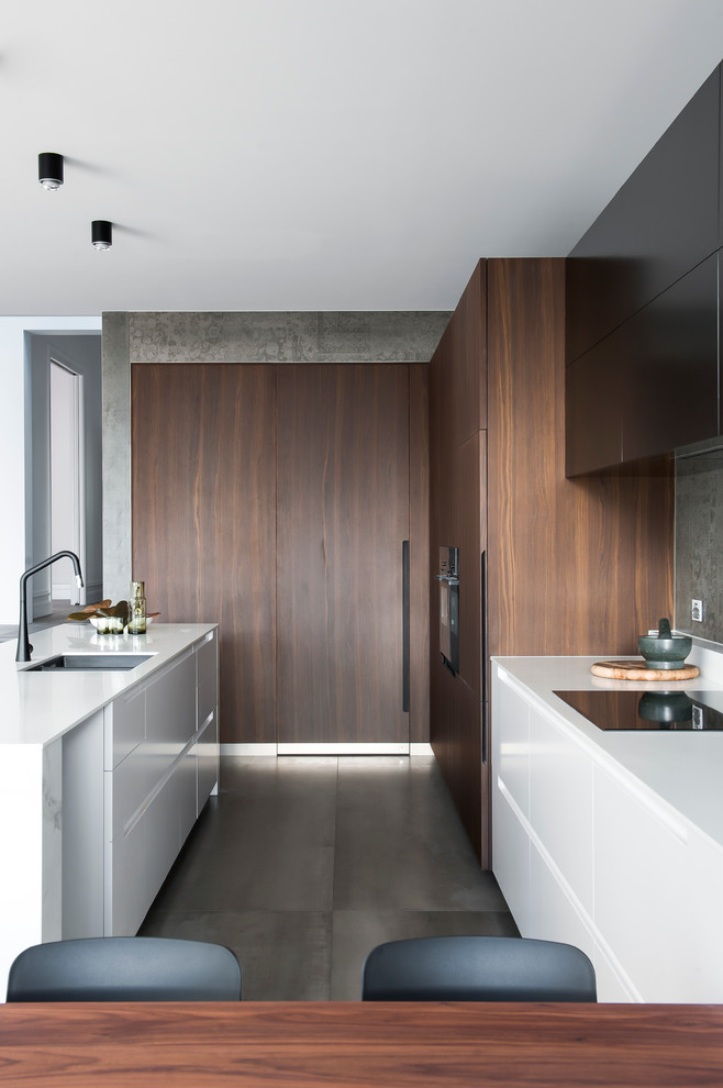 Inspiration for a mid-sized modern l-shaped eat-in kitchen in Sydney with an integrated sink, dark wood cabinets, solid surface benchtops, grey splashback, cement tile splashback, ceramic floors and with island.