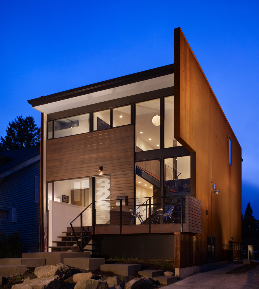 This is an example of a small modern two-storey red exterior in Seattle with wood siding and a flat roof.