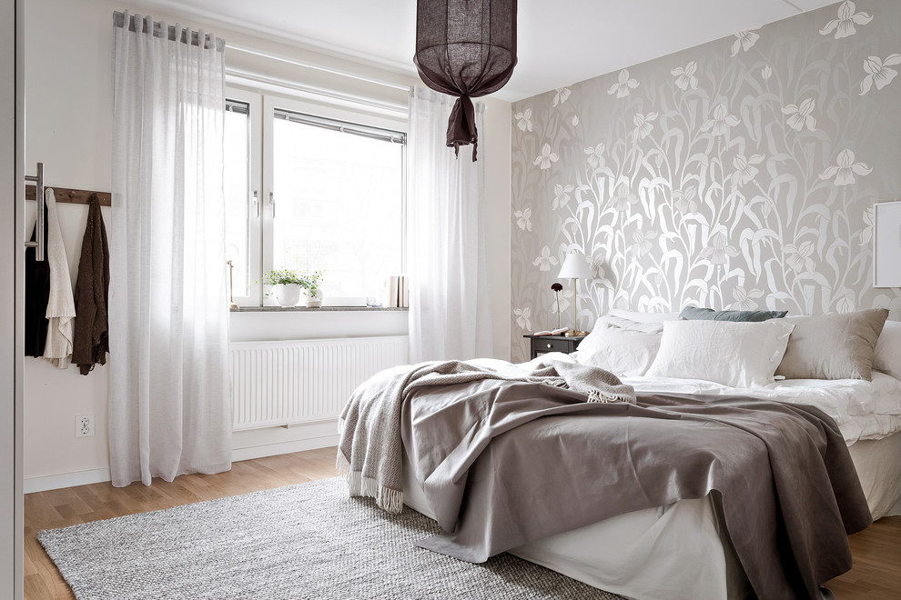 Inspiration for a mid-sized scandinavian master bedroom in Gothenburg with grey walls, medium hardwood floors and beige floor.