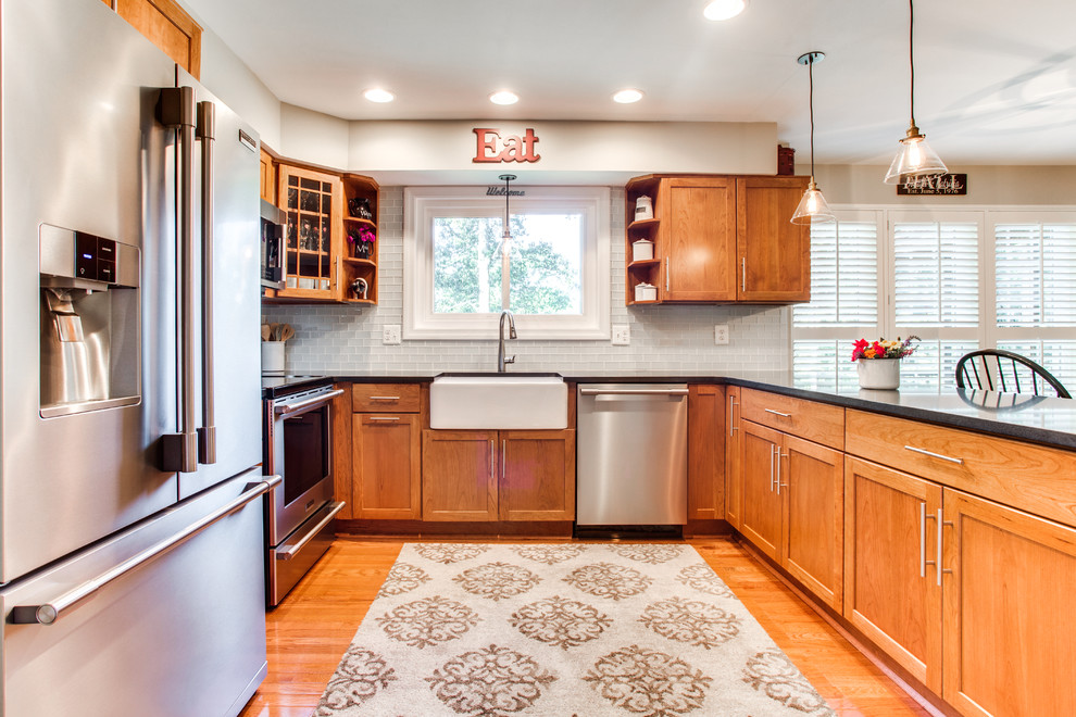 Design ideas for a small transitional u-shaped kitchen in DC Metro with a farmhouse sink, shaker cabinets, granite benchtops, grey splashback, subway tile splashback, stainless steel appliances, medium hardwood floors and a peninsula.