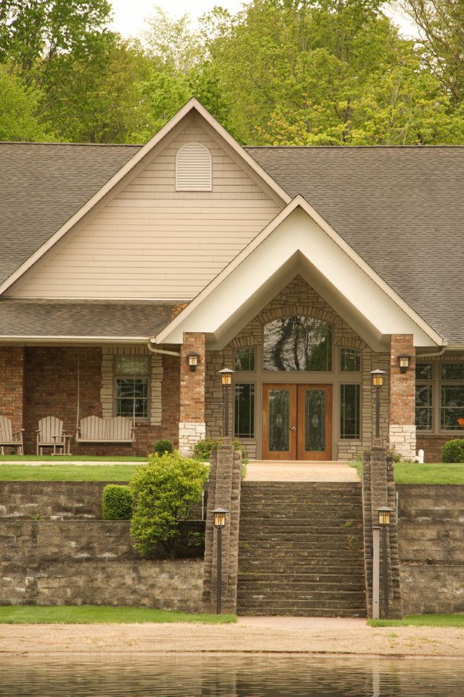 Example of a huge mountain style concrete floor and gray floor front door design with brown walls and a medium wood front door