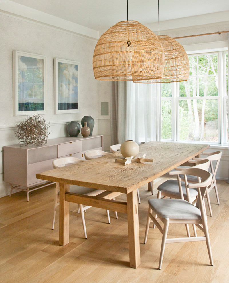 This is an example of a beach style separate dining room in New York with beige walls, medium hardwood floors and brown floor.