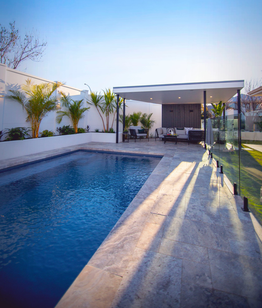 Mittelgroßer Pool hinter dem Haus in rechteckiger Form mit Sichtschutz und Natursteinplatten in Perth